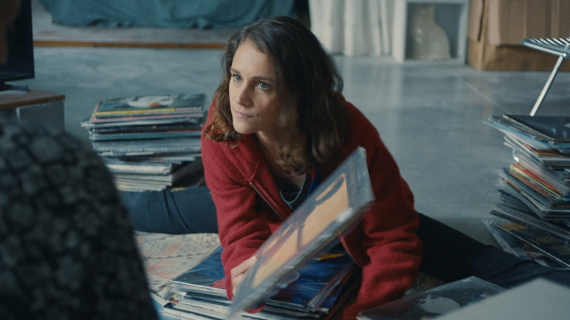 "L' Opéra - Dancing in Paris - Bitteres Wiedersehen": Zoé (Ariane Labed) sitzt auf dem Boden einer Wohnung und geht eine Sammlung von Schallplatten durch.