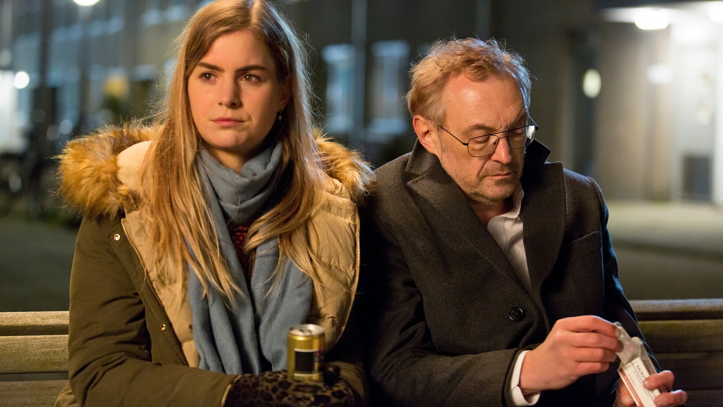 "Arthur & Claire": Arthur (Josef Hader) und Claire (Hannah Hoekstra) sitzen in nächtlicher Stunde dicht nebeneinander auf einer Bank.