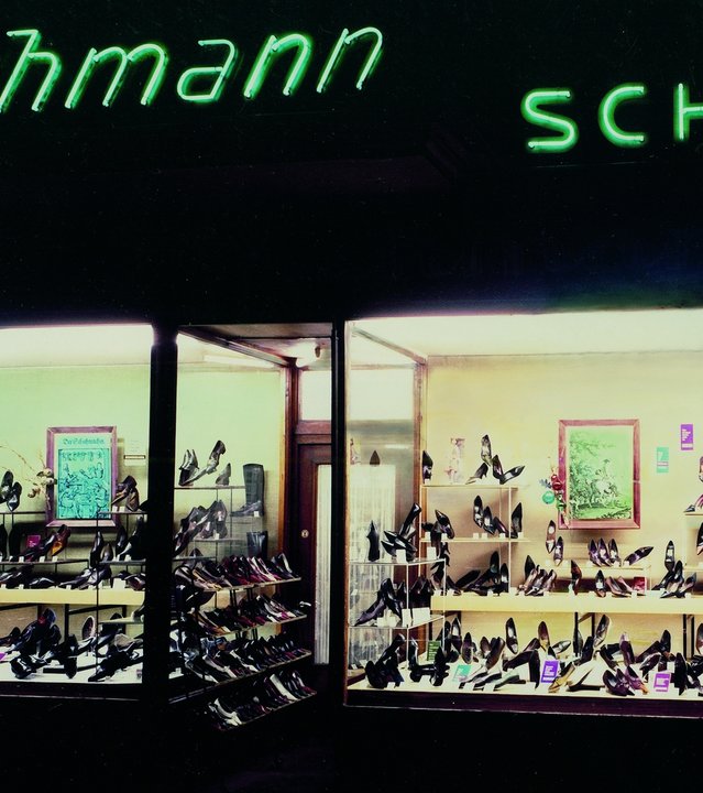 "ZDFzeit - Deutschlands große Clans: Die Deichmann-Story": Farbfoto: Fassade "Deichmann-Schuhe" mit Schaufenstern, in deren Auslage Schuhe zu sehen sind.