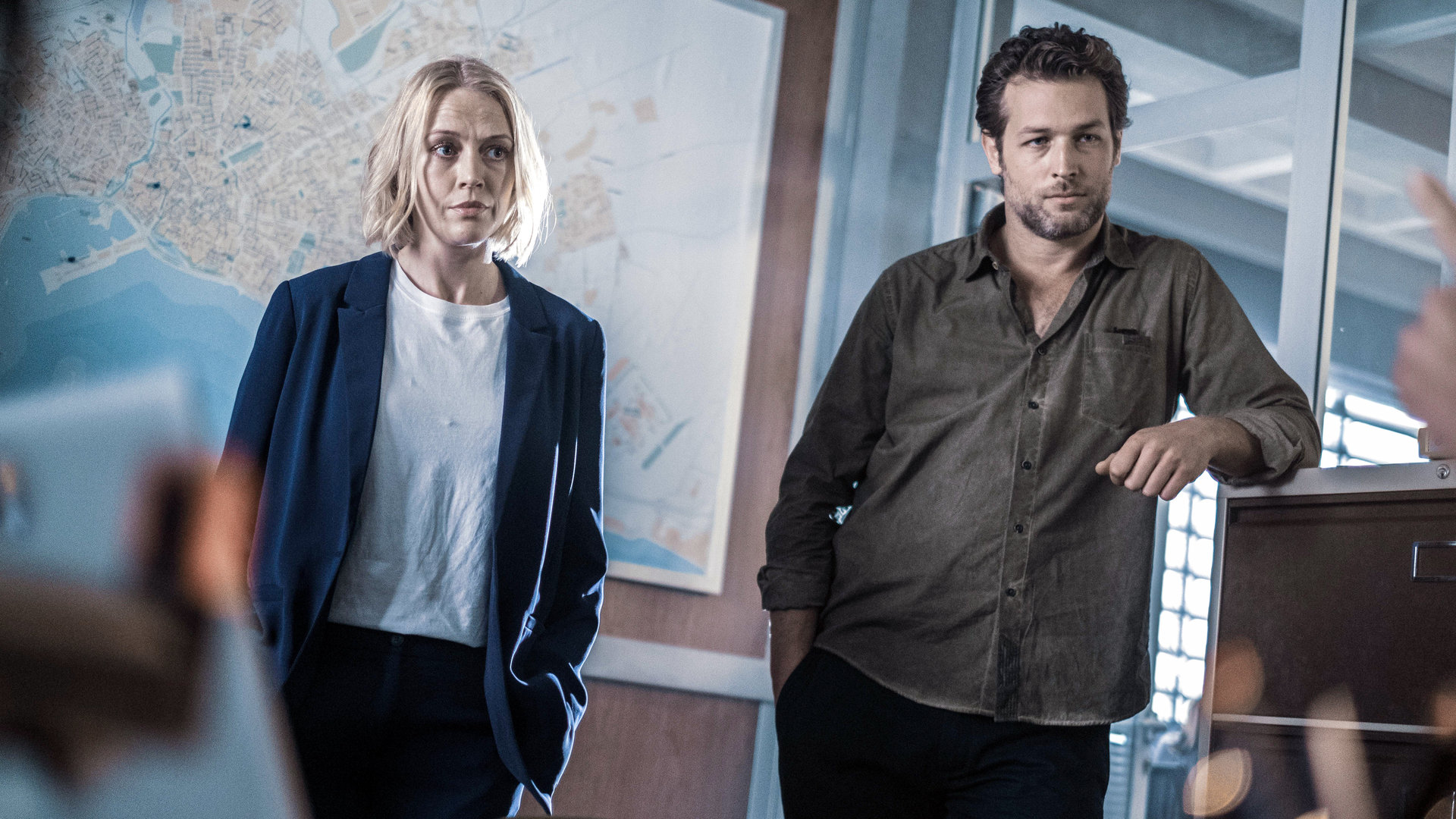 "The Mallorca Files - Mallorcas meistgesuchter Mann": Miranda (Elen Rhys) und Max (Julian Looman) stehen nebeneinander im Büro.