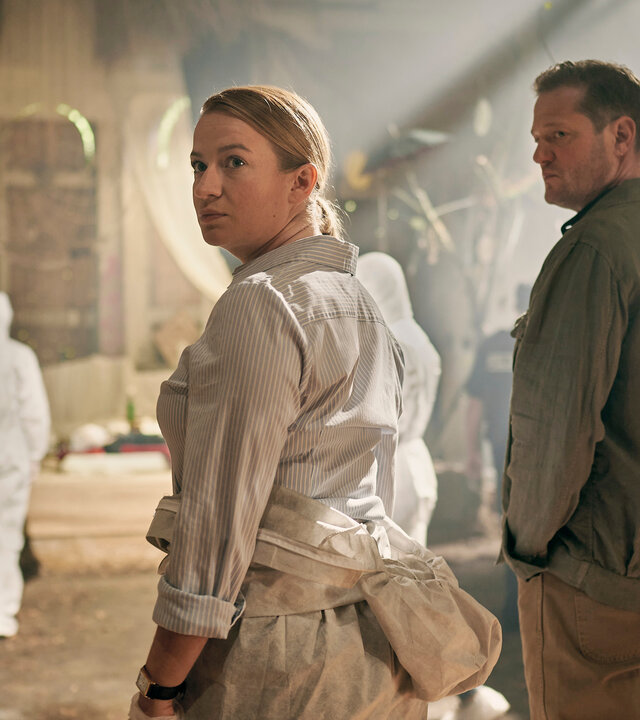"Theresa Wolff - Lost": Theresa Wolff (Nina Gummich) steht in einem großen Raum mit leichtem Lichteinfall. Neben ihr steht Bruno Lewandowski (Aurel Manthei).