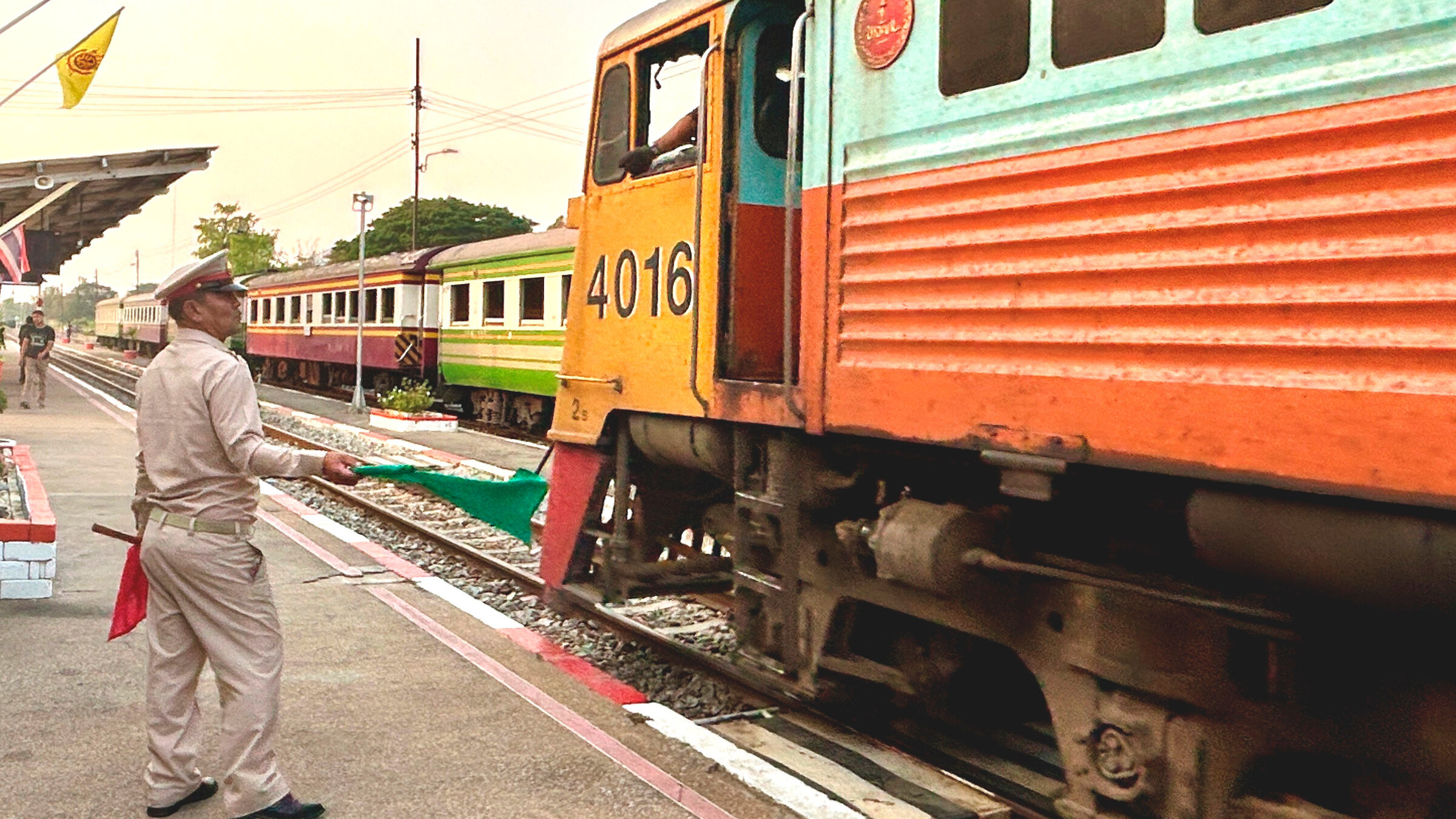 "Mit dem Zug durch Thailands Westen": Mit grÃ¼nen Fahnen geben die Fahrdienstleiter an den thailÃ¤ndischen BahnhÃ¶fen die Einfahrt frei.