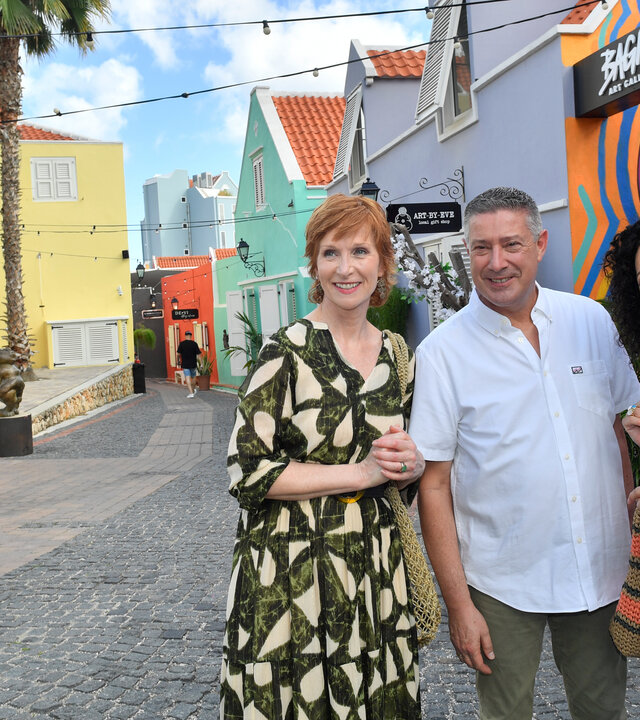 "Das Traumschiff: Curaçao": In der Stadt: Vor bunten Häusern steht Jochen Thabazi (Joachim Llambi) umringt von Hanna Liebhold (Barbara Wussow) und Birgit Schneider (Fanny Stavjanik). Sie unterhalten sich lachend.