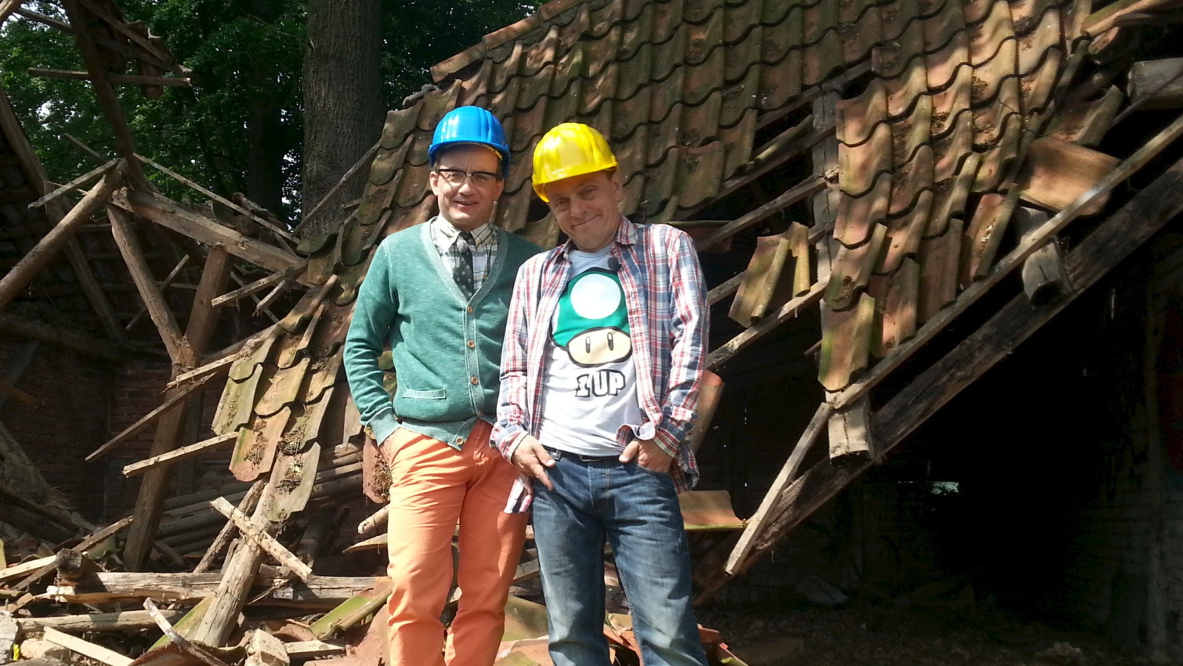 "Nicht nachmachen!": Wigald Boning und Bernhard Hoëcker stehen vor einem eingefallenen Stall. Beide tragen Schutzhelme.