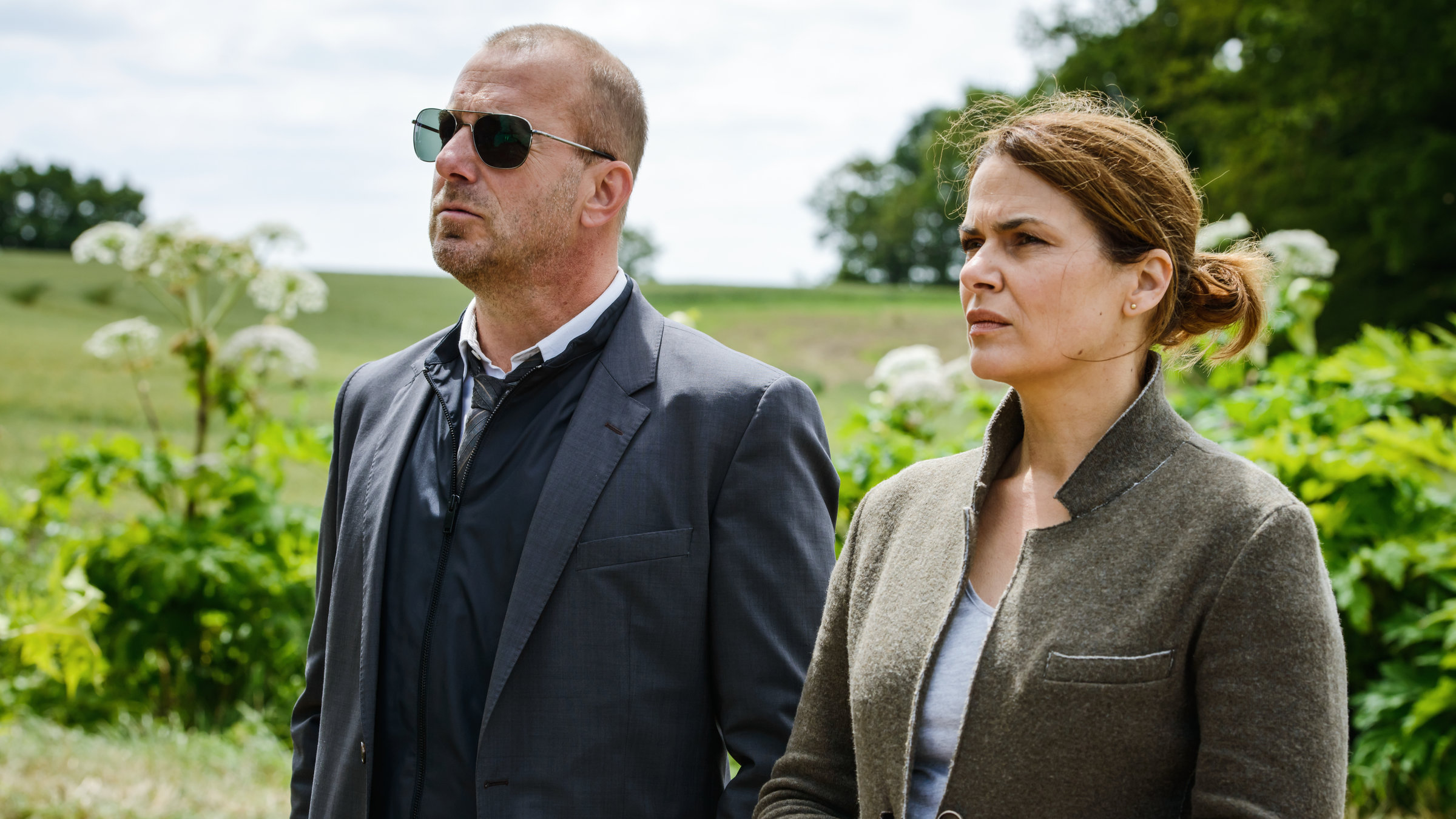 "Tod eines Mädchens - Teil 2": Simon Kessler (Heino Ferch) und Hella Christensen (Barbara Auer) stehen nebeneinander in einem Garten und schauen auf etwas außerhalb des Bildes.