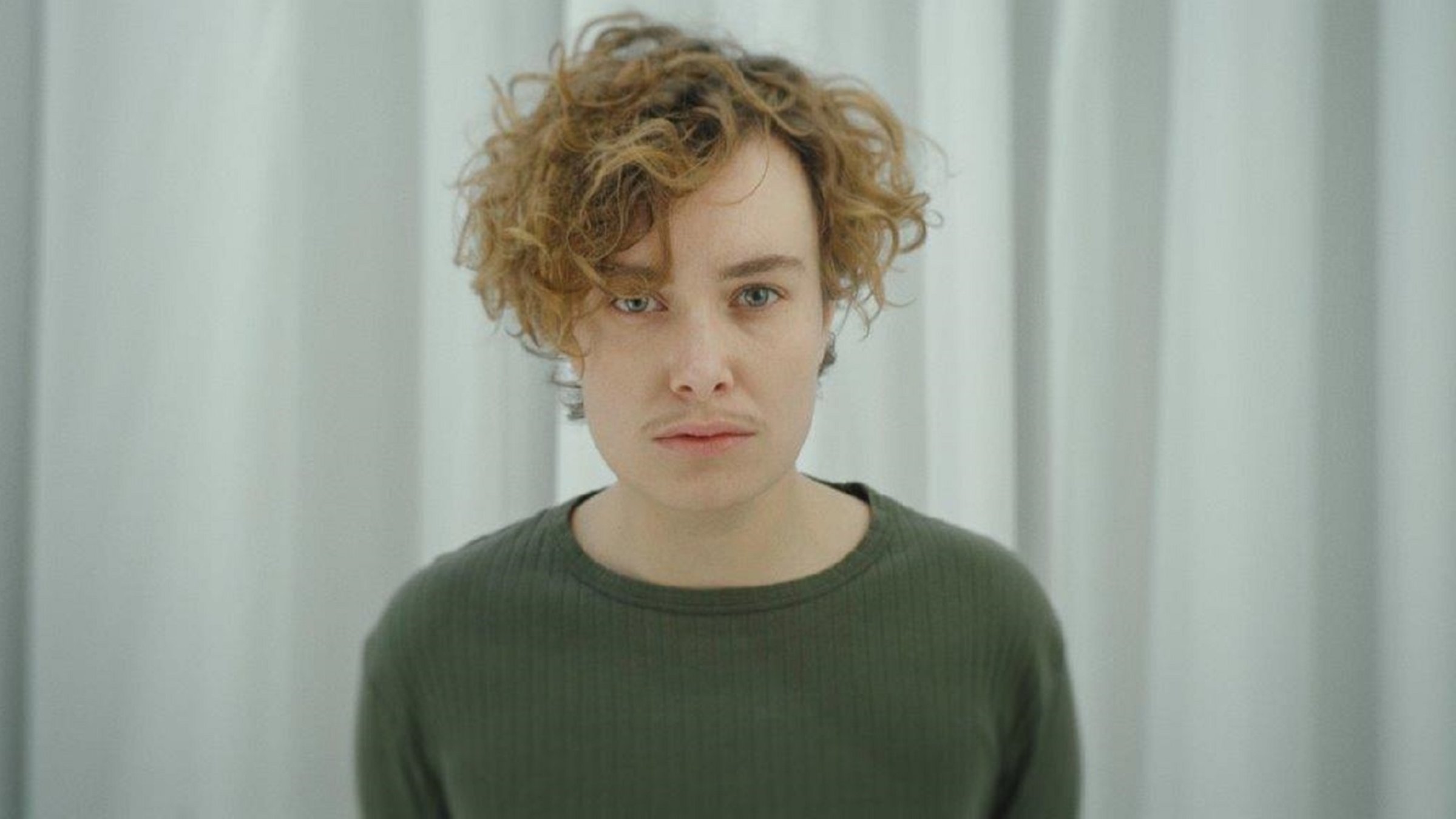 "Ab 18! - Being Sascha": Ein junger Mensch mit sowohl weiblichen als auch männlichen Attributen blickt frontal in die Kamera.