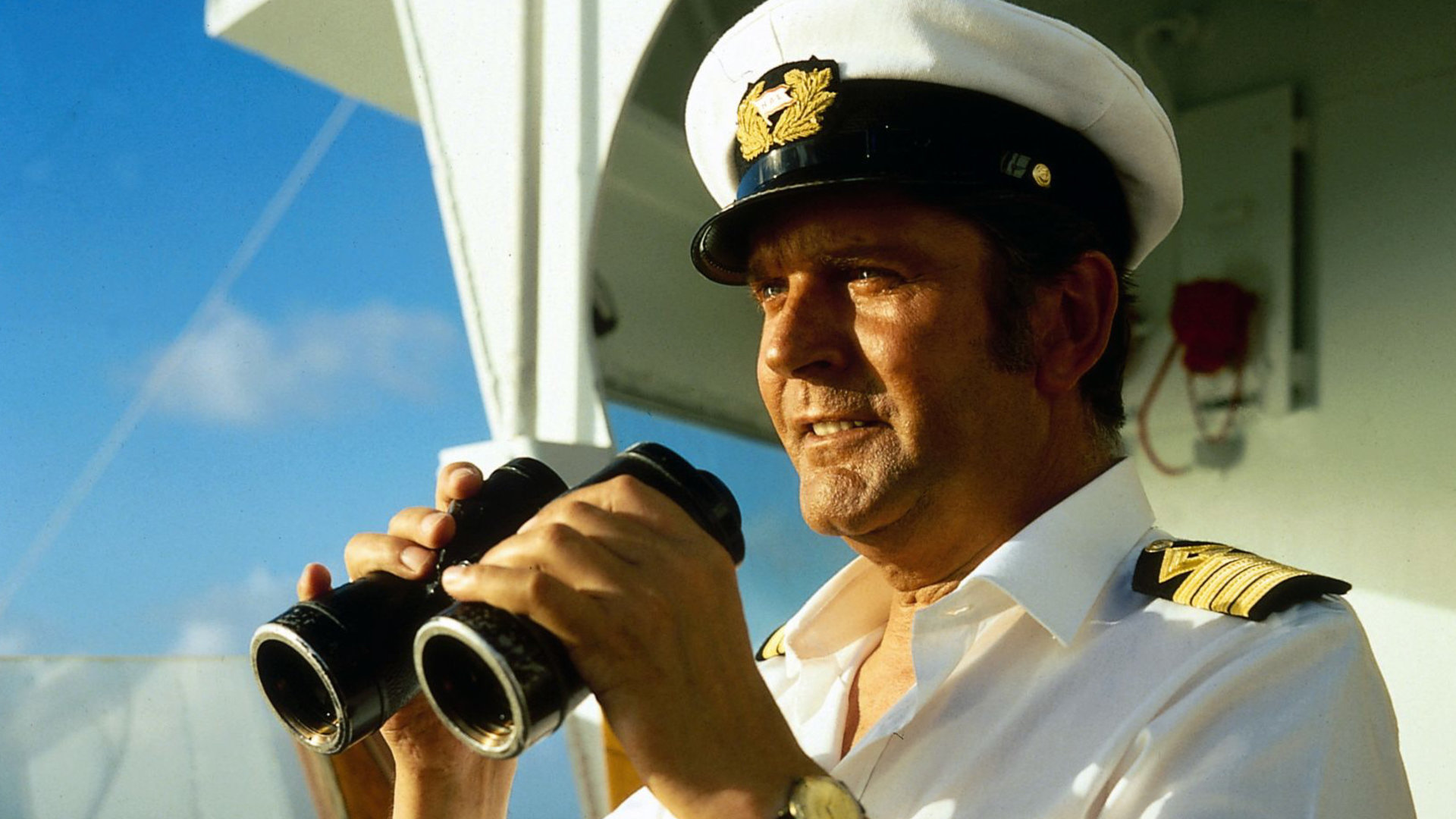 "Das Traumschiff: Cayman Islands": Kapitän Braake (Günter König) steht auf der Brücke des Traumschiffs und hält ein Fernglas in der Hand.
