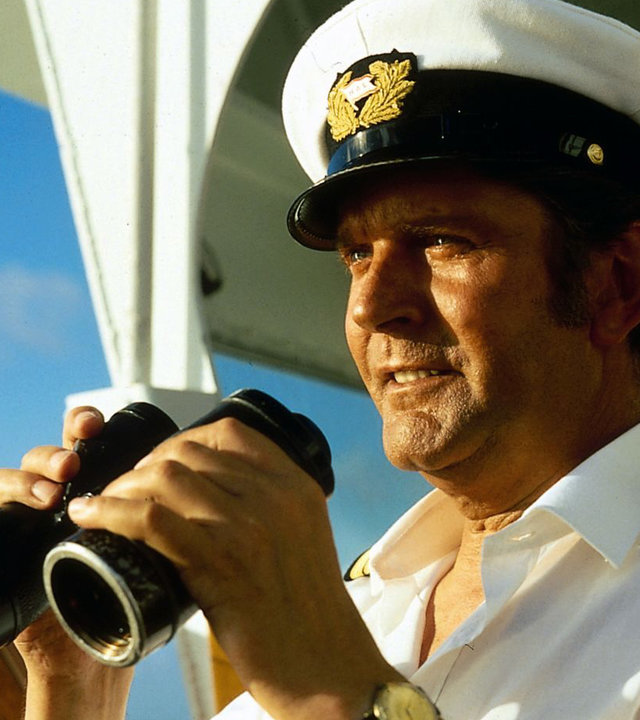 "Das Traumschiff: Cayman Islands": Kapitän Braake (Günter König) steht auf der Brücke des Traumschiffs und hält ein Fernglas in der Hand.