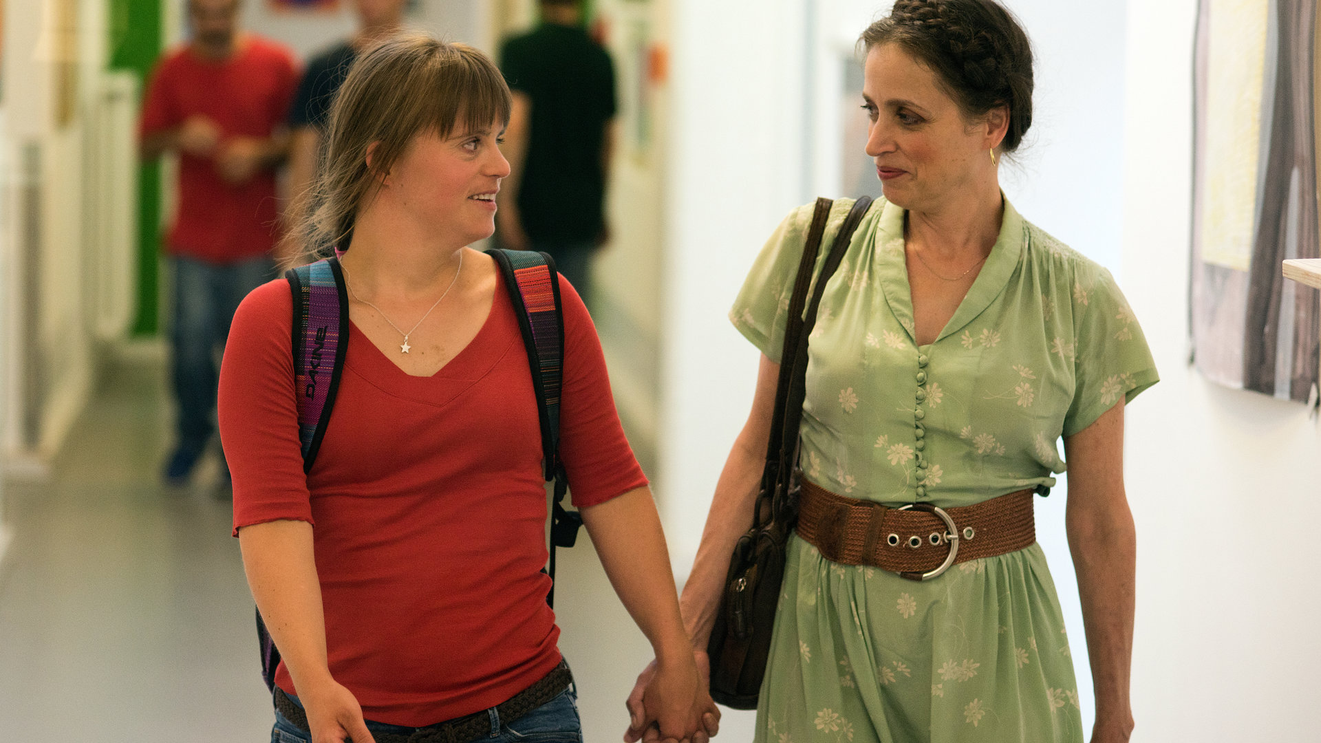"Letzte Spur Berlin - Unmündig": Frida (Juliana Götze) und Susanne Schmitz (Anna Thalbach) gehen Hand in Hand einen Gang entlang. Sie lächeln sich an.