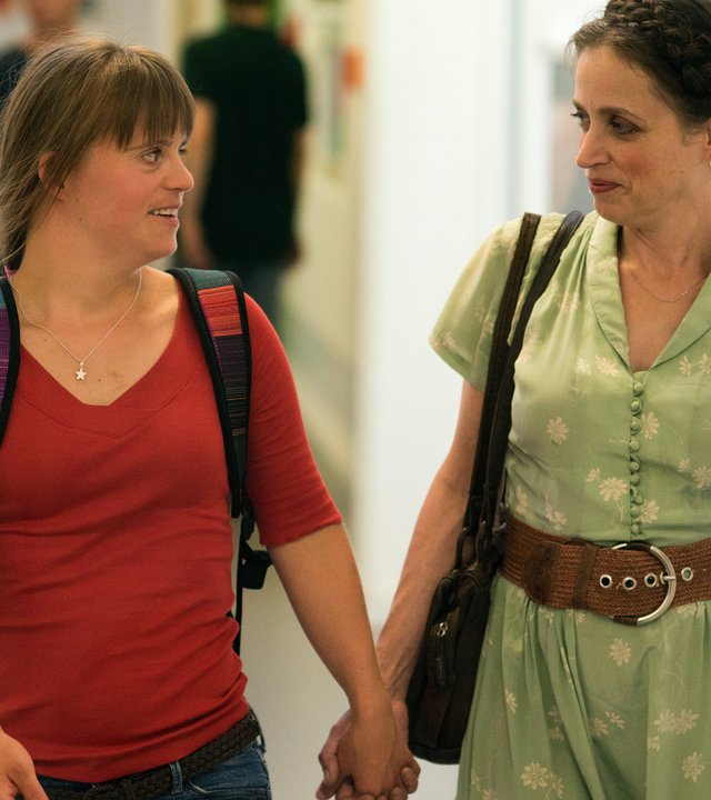 "Letzte Spur Berlin - Unmündig": Frida (Juliana Götze) und Susanne Schmitz (Anna Thalbach) gehen Hand in Hand einen Gang entlang. Sie lächeln sich an.