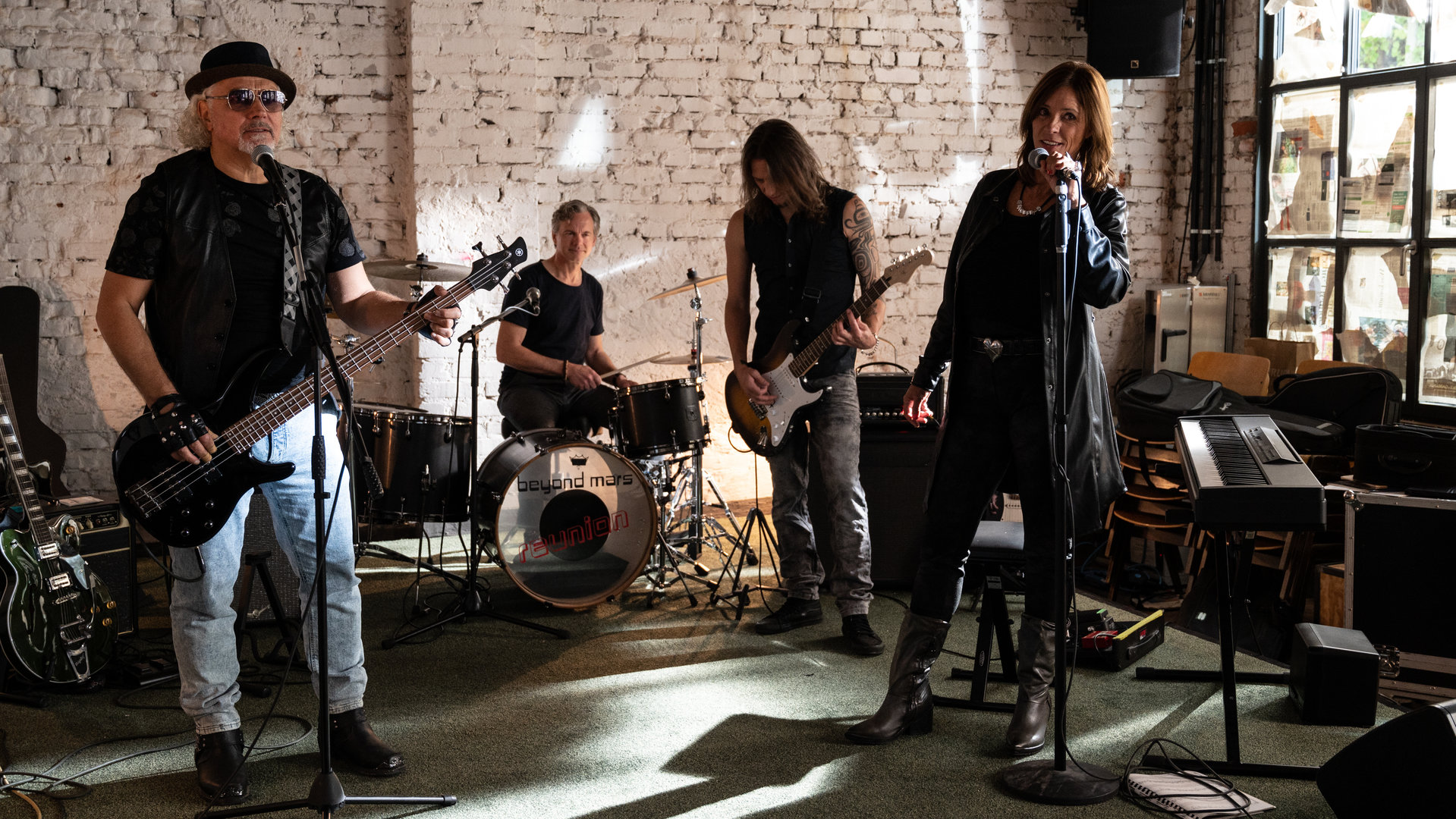 "SOKO Stuttgart - Reunion": Die Band "Beyond Mars" ist in ihrem Proberaum und macht Musik. Die Sängerin Lina Wagner (Carin C. Tietze) steht vorne am Mikrofon, der Bassist Gerry Brügge (Hansa Czypionka) etwas entfernt neben ihr und ebenso an einem Mikrofon. Hinter ihnen sieht man den Gitarristen Carlo Hahn (Alexander Scholpp) und den Schlagzeuger Florian "Flocke" Wagner (Felix Theissen). Um sie herum stehen unter anderem ein Keyboard, eine weitere Gitarre und mehrere Verstärker. Durch ein großes Fenster seitlich der Probebühne fällt Sonnenlicht ein.