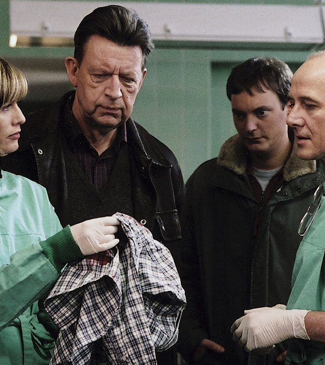 "Der letzte Zeuge - Der Mörder meines Sohnes": Dr. Judith Sommer (Gesine Cukrowski), Joe Hoffer (Jörg Gudzuhn), Etzel Hanisch (Daniel Krauss) und Dr. Robert Kolmaar (Ulrich Mühe) stehen im Obduktionssaal und begutachten ein Kleidungsstück.