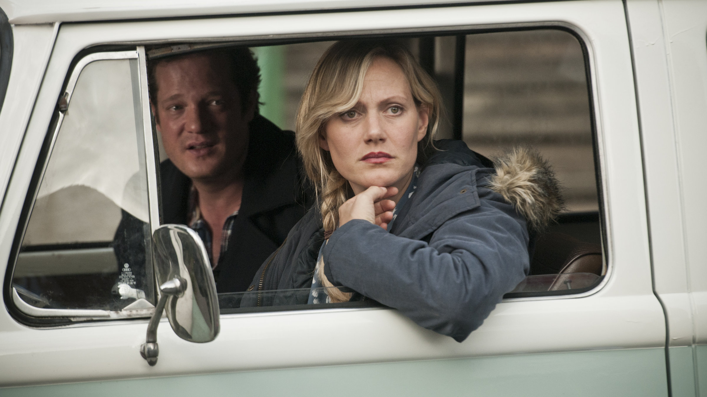 "Mordshunger - Verbrechen und andere Delikatessen - Eine Leiche zum Dessert": Kriminalkommissar Max (Aurel Manthei) und Britta (Anna Schudt) sitzen zusammen in einem Auto und schauen durch das geöffnete Fenster hinaus.