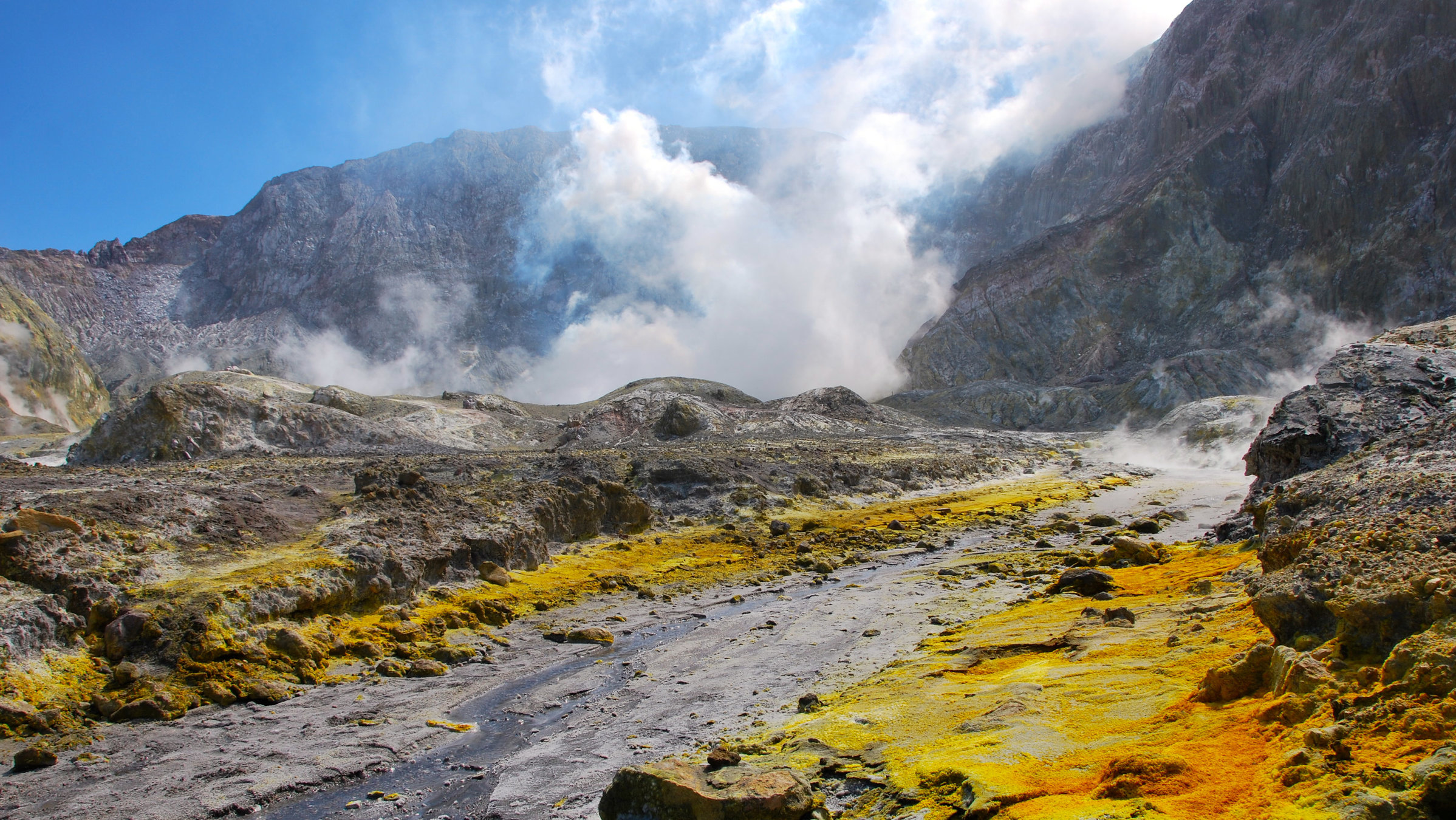 "Terra X: Abenteuer Neuseeland - 2. Vorstoß ins Unbekannte": Blick auf den Vulkan White Island, der von Schwefelflächen umgeben ist. Man sieht eine Dampfwolke im Hintergrund.