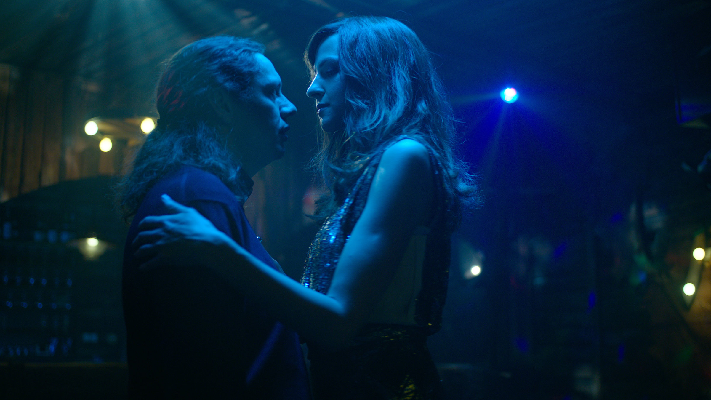 "Parfüm - Synthese": Daniel "Zahnlos" Sluiter (Christian Friedel) und Elena Seliger (Natalia Belitski) tanzen miteinander auf einer dunklen Tanzfläche und sehen sich gegenseitig tief in die Augen.