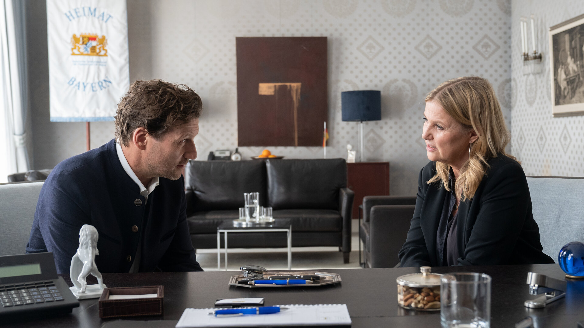 "Die Chefin - Blutschuld": Im Büro von Thomas Faber (Thomas Unger, l.) sitzen dieser und Vera Lanz (Katharina Böhm, r.) nebeneinander auf den Besucherstühlen vor Fabers Schreibtisch. Sie wenden sich einander zu, Faber beugt sich leicht nach vorne.