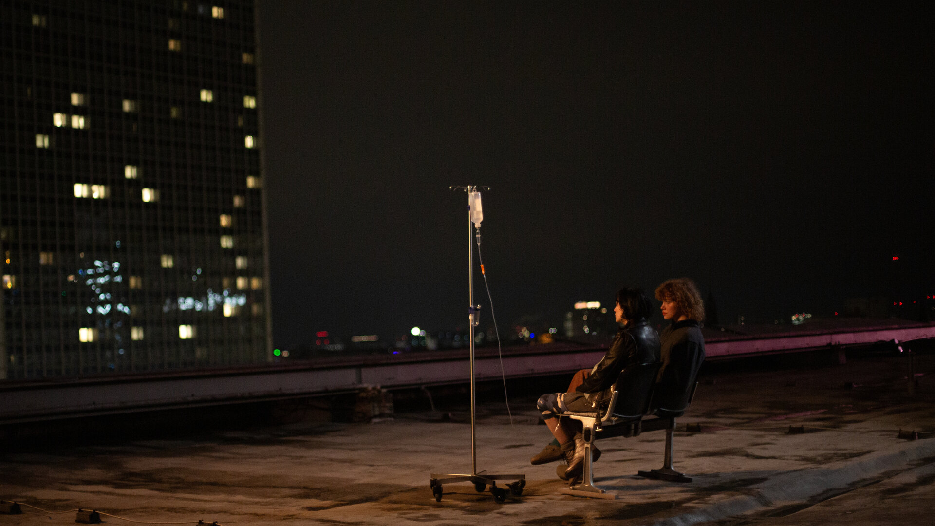 "PUSH - Stille": Melek Yalcin (Zeynep Bozbay) und Greta Malinger (Lydia Lehmann) sitzen in der Nacht auf einer Bank auf dem Dach des Krankenhauses und unterhalten sich.
