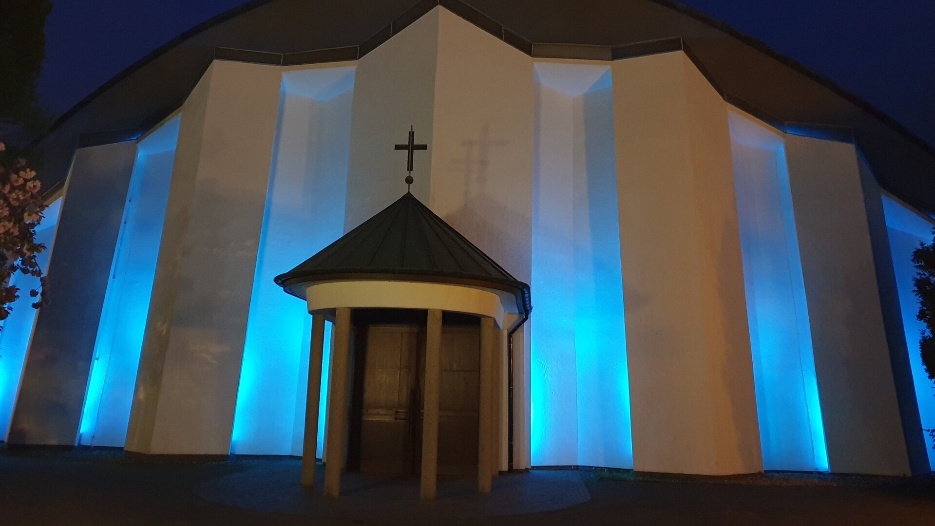 "Katholischer Gottesdienst - Keine Panik! Es ist Advent.": Außenansicht von St. Suitbert mit stimmungsvoller Abendbeleuchtung