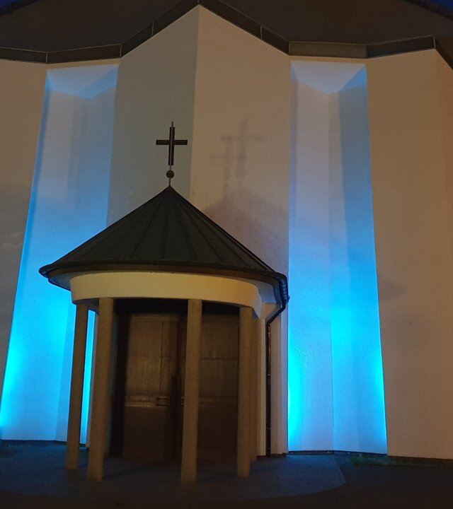 "Katholischer Gottesdienst - Keine Panik! Es ist Advent.": Außenansicht von St. Suitbert mit stimmungsvoller Abendbeleuchtung