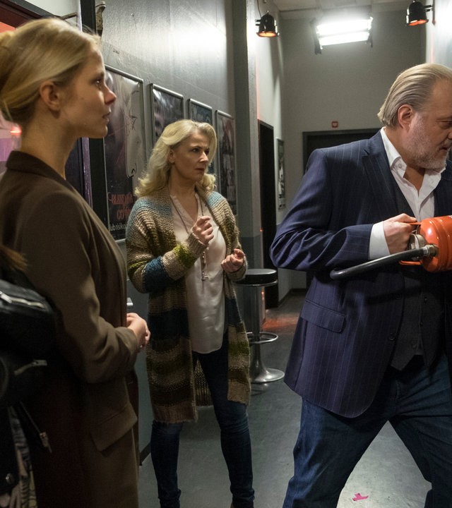 "Der Alte - Die Kunst des Scheiterns": Die Besitzerin des Clubs Anika (Anna Lena Class), Julia Graupner (Sinja Dieks) und Dr. Franziska Sommerfeld (Christina Rainer) sehen aufgeregt dabei zu wie Hauptkommissar Richard Voss (Jan-Gregor Kremp) die verschlossene Toilettentür mit Hilfe eines Feuerlöschers aufbricht.