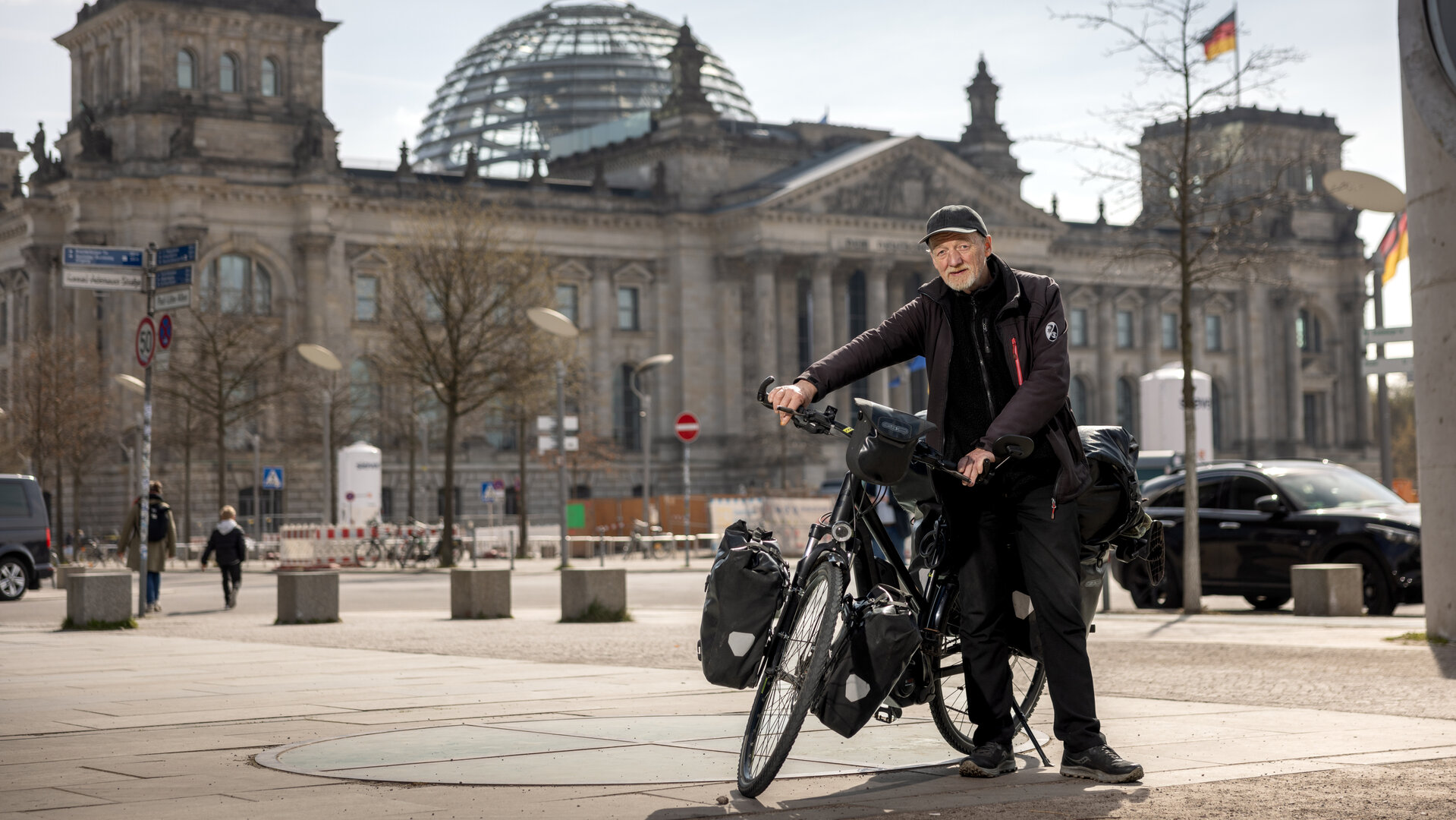 "einfach Mensch - Hartmut Nölling: Der letzte Landstreicher": Hartmut Nölling steht mit seinem Fahrrad vor dem Deutschen Bundestag.