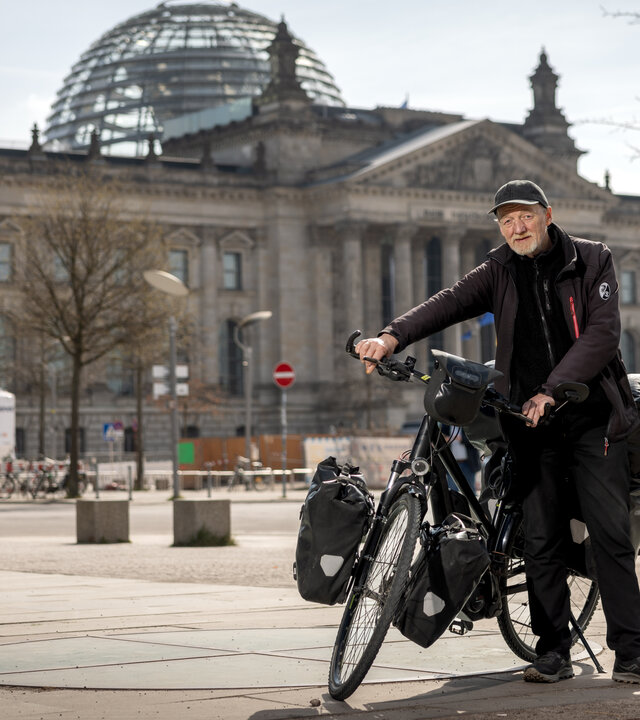 "einfach Mensch - Hartmut Nölling: Der letzte Landstreicher": Hartmut Nölling steht mit seinem Fahrrad vor dem Deutschen Bundestag.