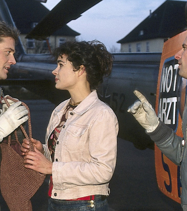 "Die Rettungsflieger - Der verflixte Tag": Jan Wollcke (Oliver Hörner) und Jens Blank (Nicolas König) stehen am Hubschrauber neben Madeleine (Caroline Kiesewetter). Beide reden intensiv auf sie ein.