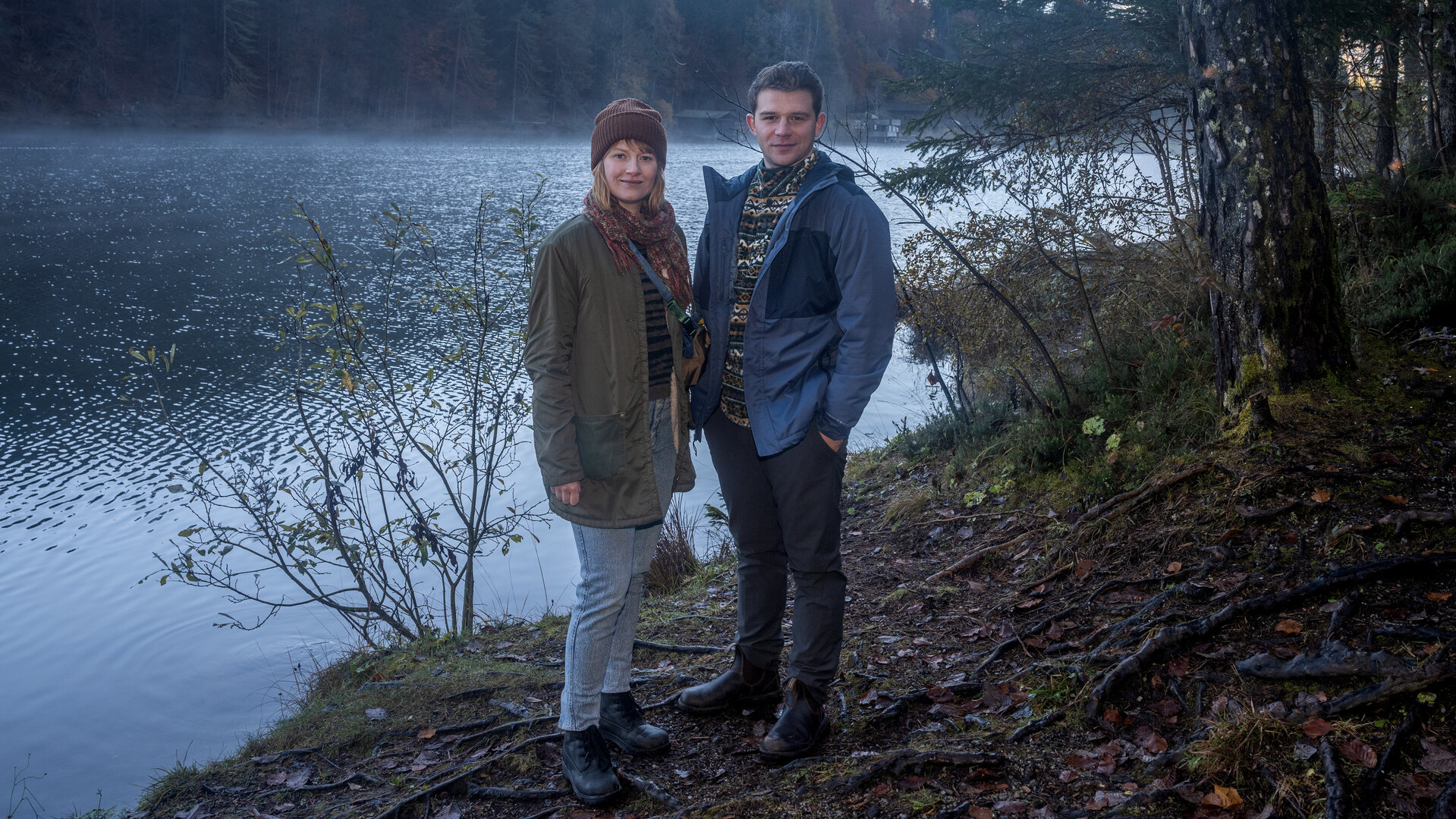 "Schnee von Gestern - Landkrimi": Chefinspektorin Melanie Grandits (Marlene Hauser) und Chefinspektor Martin Steiner (Simon Morzé) stehen am Ufer.