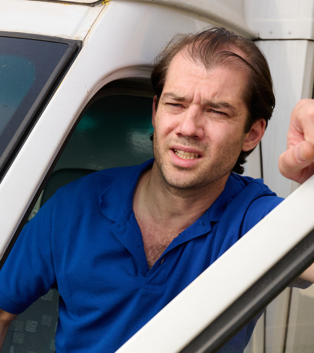 "Aufgestaut - Lew": Paketfahrer Lew (Nicolas Garin) hat die Fahrertür seines Lieferwagens geöffnet und schaut kritisch heraus.