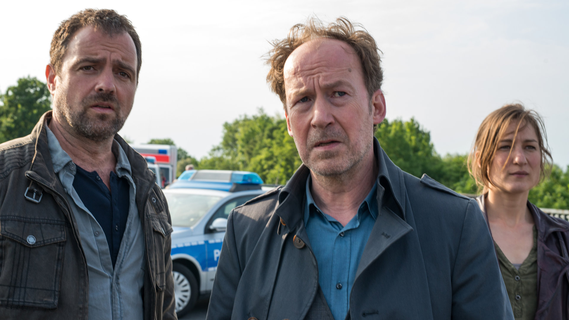 "Neben der Spur - Dein Wille geschehe": Ruiz (Juergen Maurer), Joe (Uli Noethen) und Anna (Marie Leuenberger) in Nahaufnahme. Sie stehen nebeneinander und blicken in die gleiche Richtung.