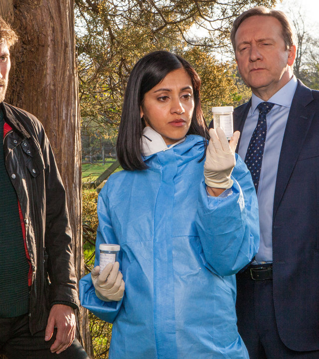 "Inspector Barnaby - Und wo sind die Leichen": Charlie Nelson (Gwilym Lee), Dr. Kam Karimore (Manjinder Virk) und Inspector Barnaby (Neil Dudgeon) haben Indizien gefunden und betrachten ein Reagenzglas mit Textil-Gewebeproben.