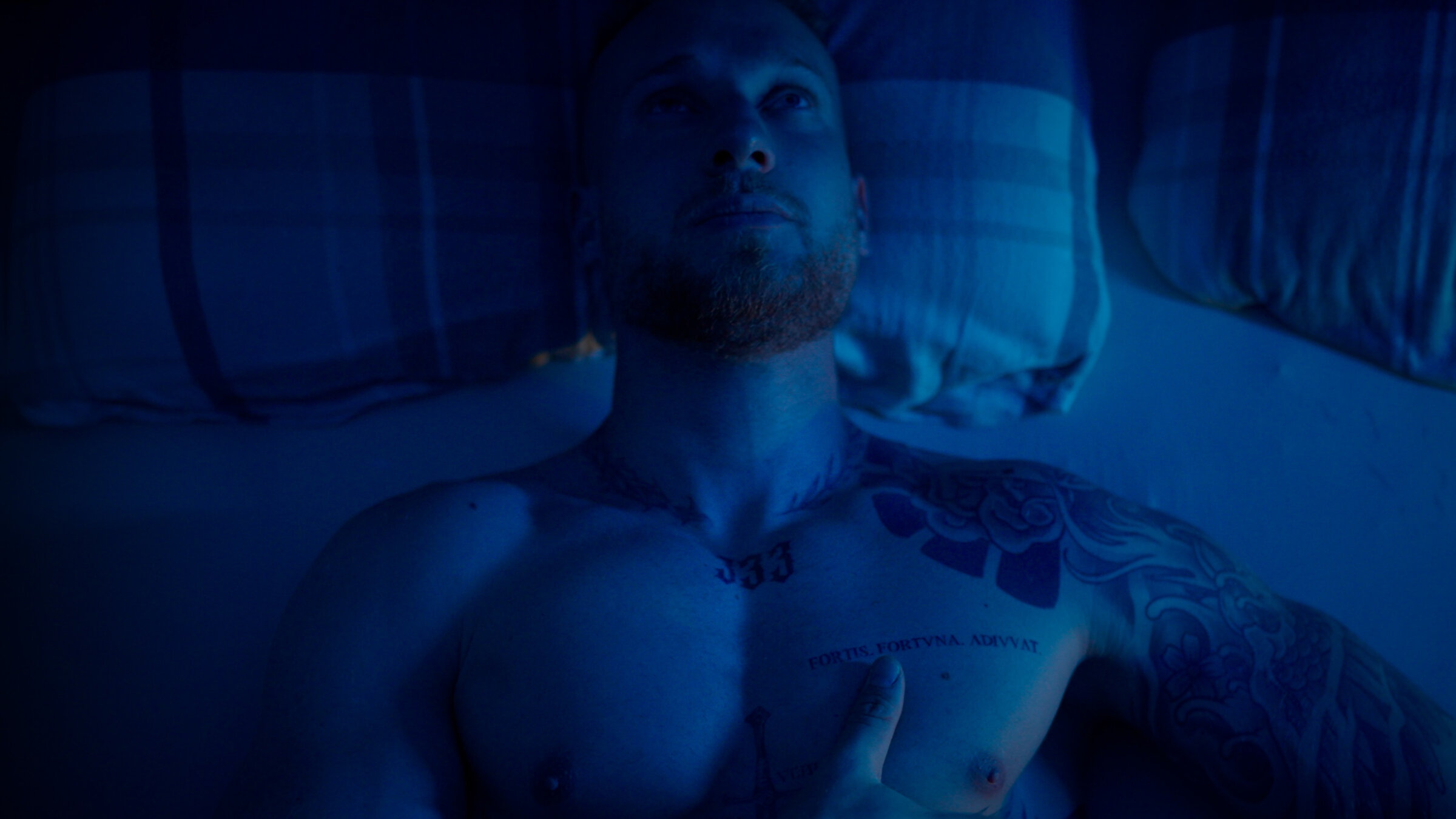 "37°Leben: Comeback: Spielsucht": Foto in dunklen Schwarz- und Blautönen: Der Oberkörper Toms liegt im Bett, der Kopf auf einem Kopfkissen, sein Blick geht nach oben.