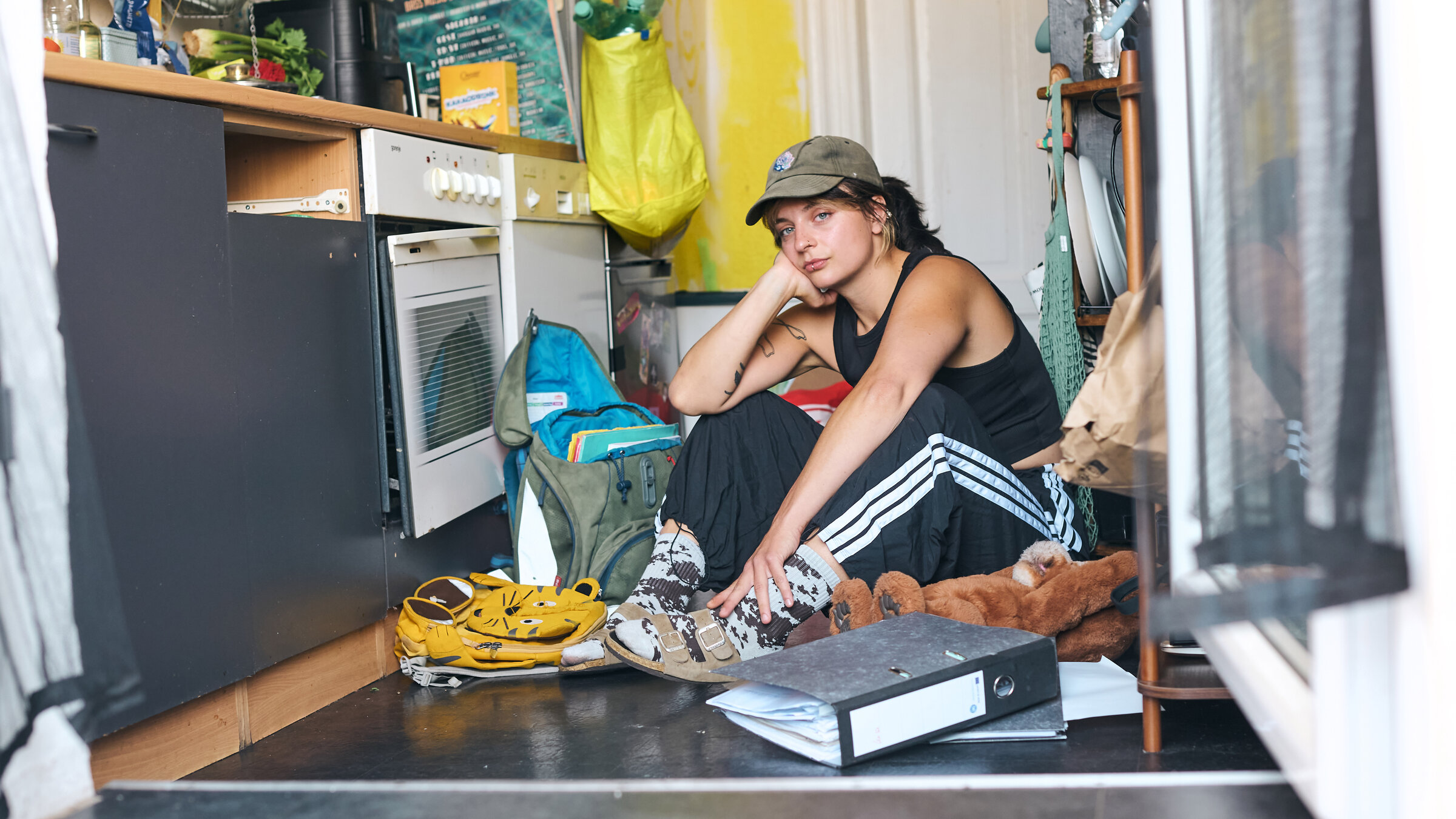 "37°Leben: Knapp bei Kasse: Arm trotz Arbeit": Halbnahe: Luisa sitzt auf Boden in Küche und blick nach vorn.