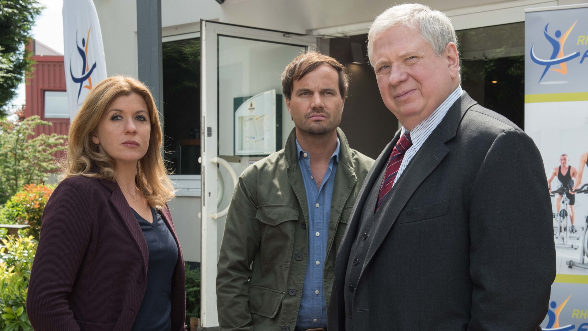 „Der Staatsanwalt – Alte Freunde“: Kerstin Klar (Fiona Coors), Christian Schubert (Simon Eckert) und Bernd Reuther (Rainer Hunold) stehen vor einem Fitnessstudio.