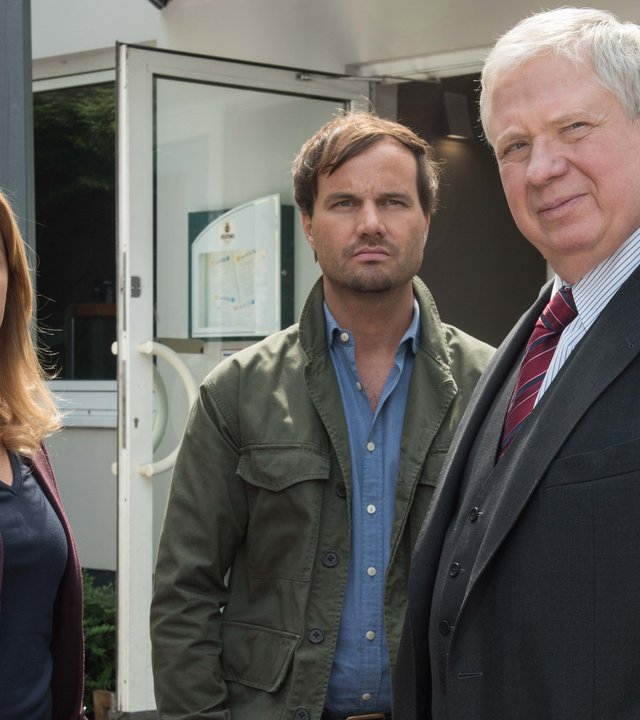„Der Staatsanwalt – Alte Freunde“: Kerstin Klar (Fiona Coors), Christian Schubert (Simon Eckert) und Bernd Reuther (Rainer Hunold) stehen vor einem Fitnessstudio.