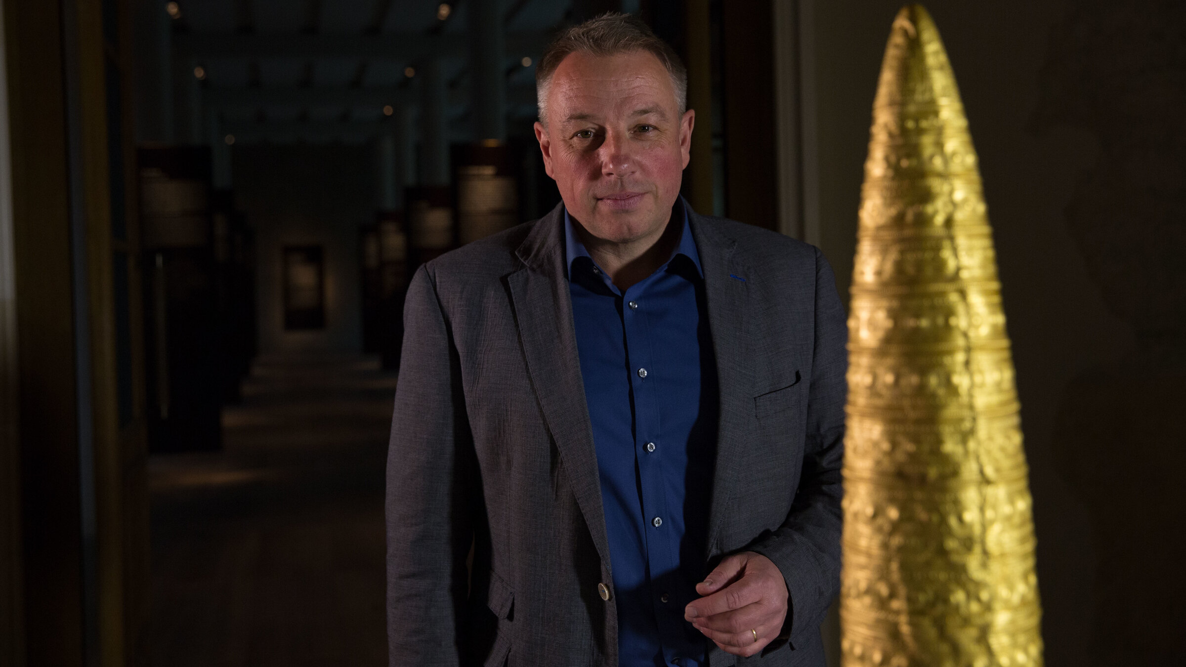 "Terra X: Zeitreise - Die Welt im Jahr 1000 v. Chr.": Prof. Matthias Wemhoff im Neuen Museum Berlin. Im Vordergrund sieht man einen großen, spitz nach oben laufenden Goldhut.