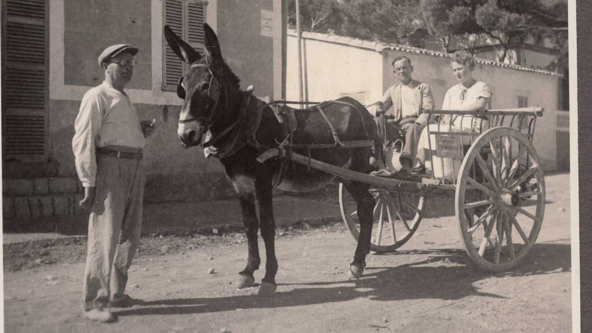 "ZDF-History: Mallorca - Eine deutsche Liebe": Schwarz-Weiß-Foto: Ein Paar sitzt in einem Eselskarren, davor steht ein Mann mit Brille und Baskenmütze.