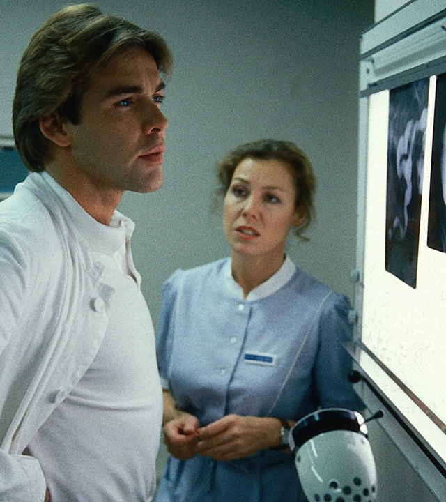 "Die Schwarzwaldklinik - Sterbehilfe": Dr. Brinkmann (Sascha Hehn) und Schwester Christa (Gaby Dohm) stehen nebeneinander und schauen sich Röntgenaufnahmen an. Christa sieht verunsichert aus.