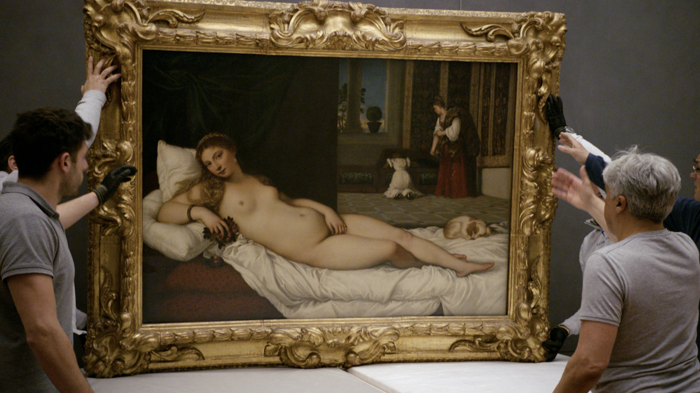 "In den Uffizien": Zwei Restauratoren fassen den Rahmen der großen Ölgemäldes mit einem liegenden Akt darauf an und hängen es vorsichtig ab.