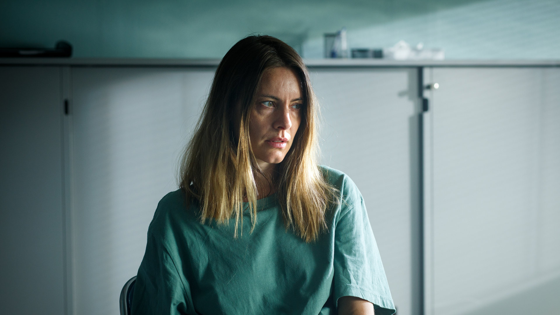 "Mord im Mittsommer - Vicky": Vicky (Malin Crépin) sitzt an einem Tisch und sieht nachdenklich zur Seite. Im Hintergrund steht ein grauer Aktenschrank.
