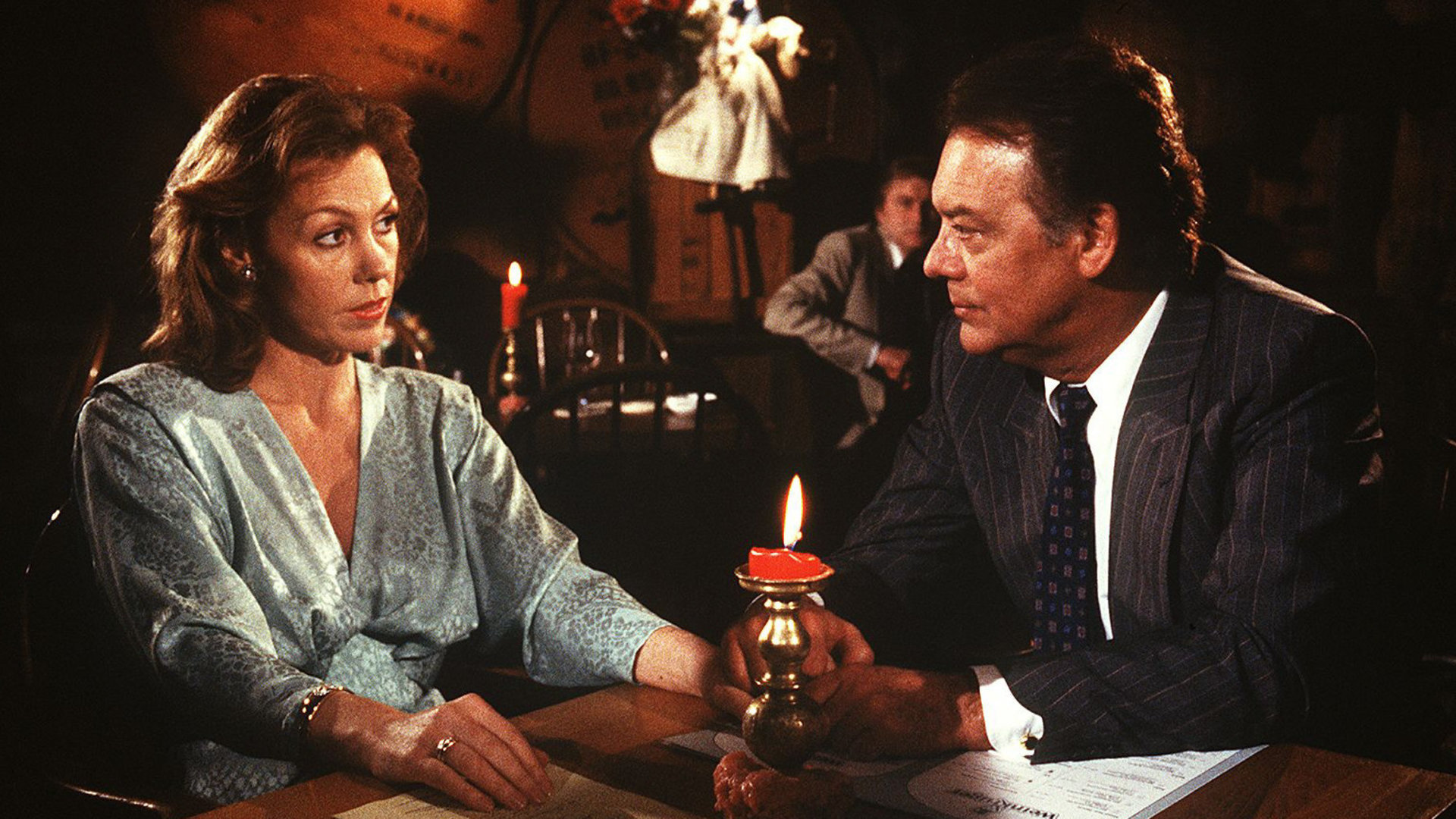 "Die Schwarzwaldklinik - Alles Theater": Christa (Gaby Dohm) und ihr Mann Prof. Brinkmann (Klausjürgen Wussow) sitzen im Restaurant am Tisch und unterhalten sich.