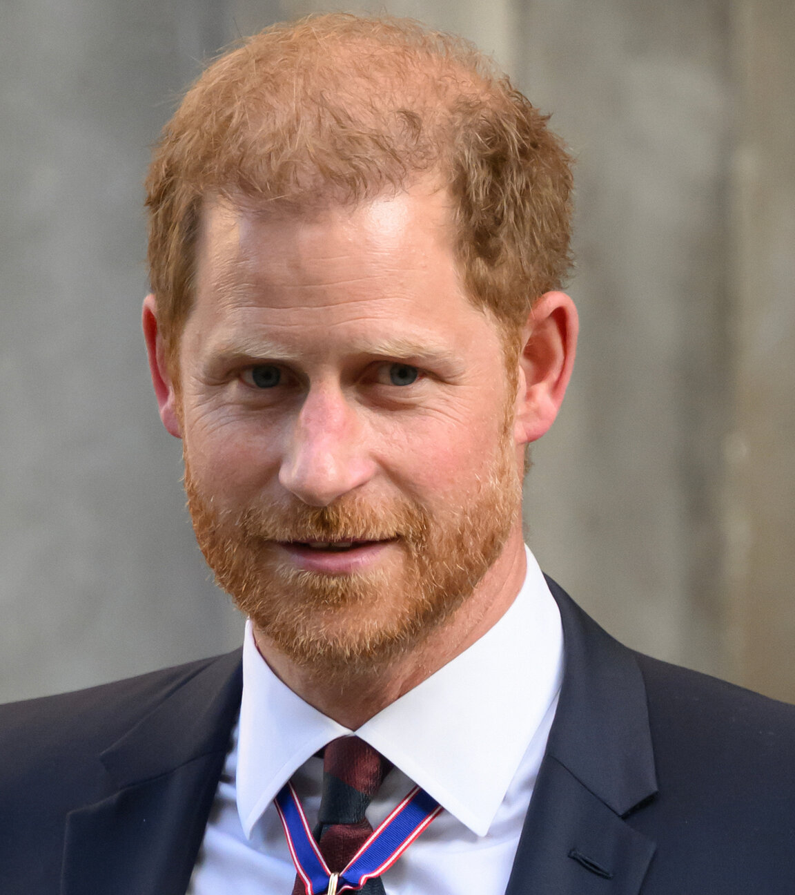 "ZDFroyal: Harry - der verlorene Prinz": Portraitaufnahme von Prinz Harry. Er trägt einen dunklen Anzug, der mit Orden geschmückt ist und lächelt verhalten knapp an der Kamera vorbei.