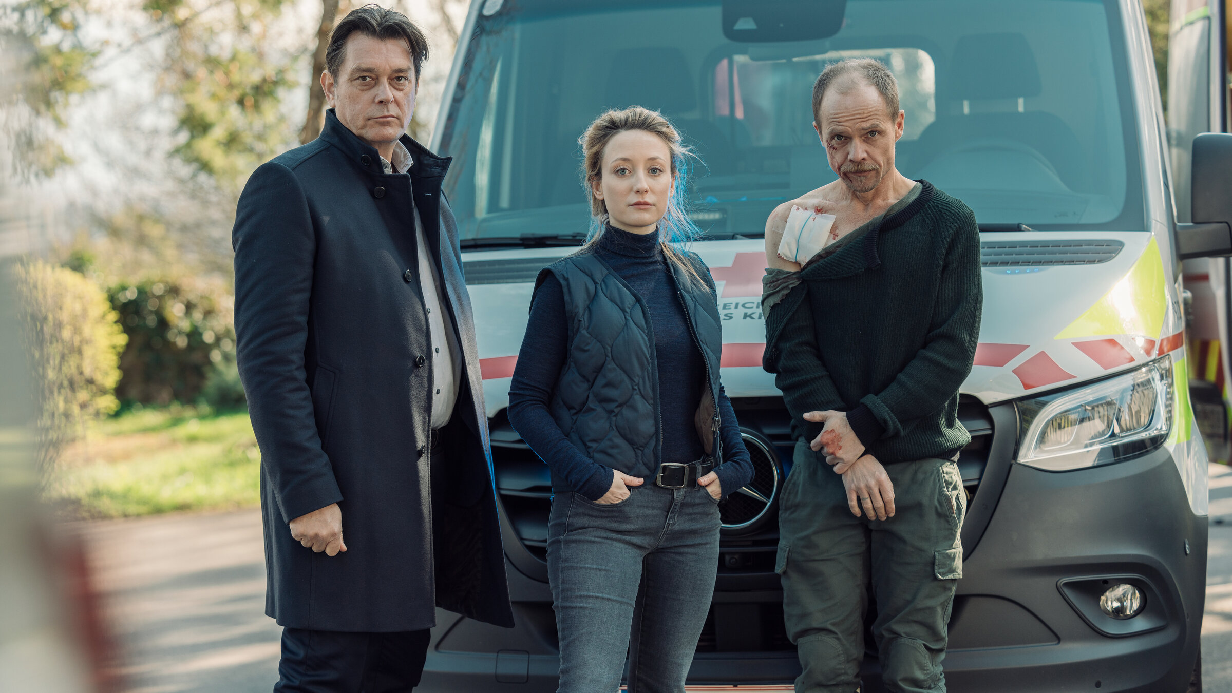 "Die Toten vom Bodensee - Die Messias": Micha Oberländer (Matthias Koeberlin), Luisa Hoffmann (Alina Fritsch) und Thomas Komlatschek (Hary Prinz) stehen zusammen vor einem Notarztwagen. Micha Oberländer (Matthias Koeberlin) ist verletzt.