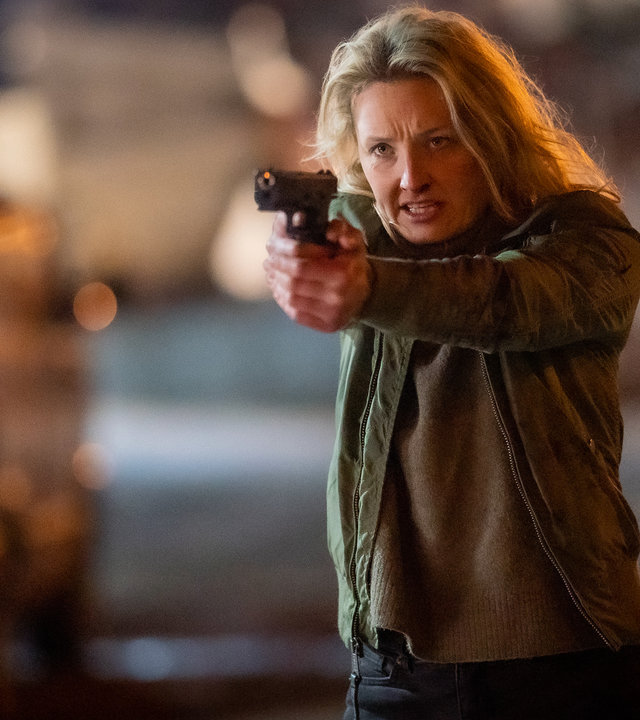 "Furia (4)": Auf einem verlassenen Gelände zielt Ragna (Ine Marie Wilmann) entschlossen mit einer Waffe auf jemanden außerhalb des Bildes.