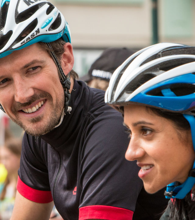 "Inspector Barnaby - Der Tod radelt mit": DS Charlie Nelson (Gwilym Lee) lächelt Dr. Kam Karimore (Manjinder Virk) zu. Beide warten, mit Helm und Trikot auf den Startschuss beim Radrennen.
