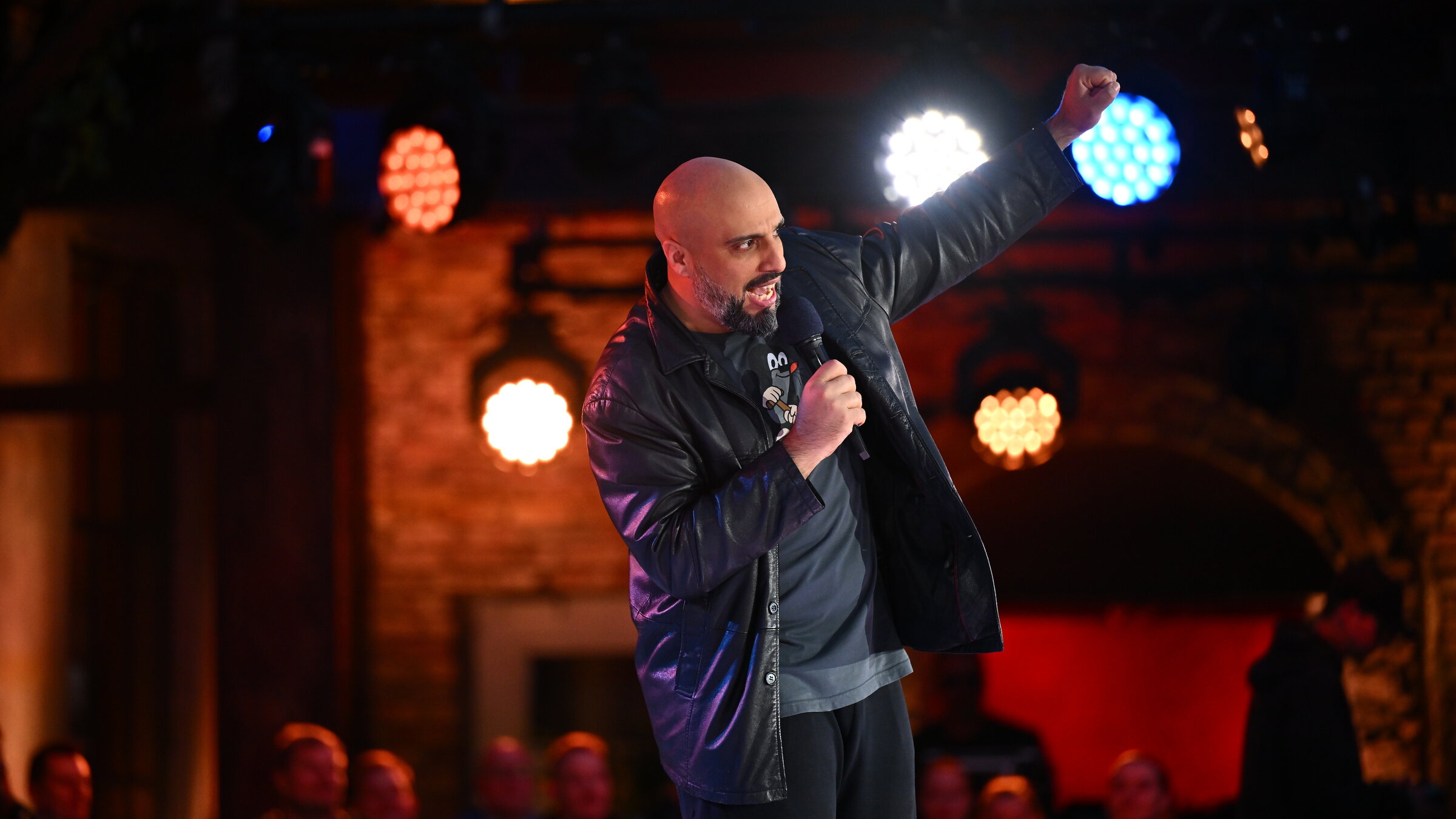 "Der ZDF Comedy Sommer": Comedian Abdelkarim steht auf der Bühne, hält ein Mikrofon in der Hand und gestikuliert Richtung Publikum.
