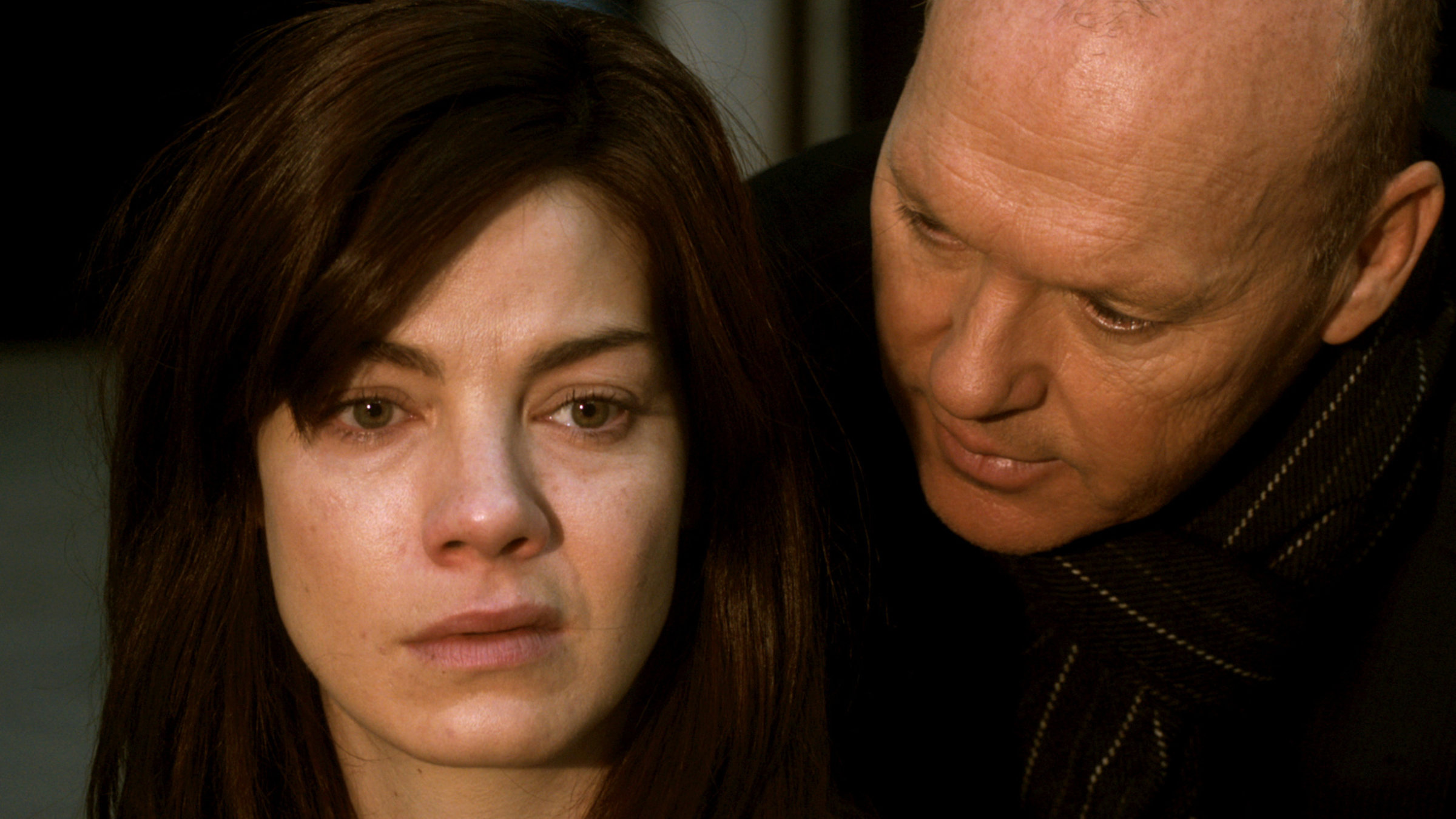 "Das Penthouse": Sara (Michael Keaton) steht hinter Sara (Michelle Monaghan) und schaut sie intensiv an.