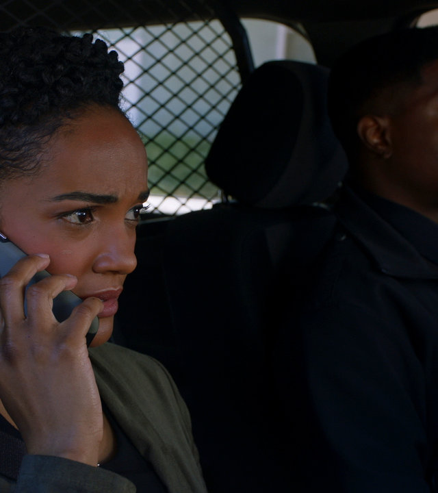 "The Rookie - Der zweite Sohn": Thorsen (Tru Valentino) und Harper (Mekia Cox) sitzen zusammen in einem Streifenwagen. Während Thorsen konzentriert am Steuer sitzt, telefoniert Harper mit ihrem Handy.