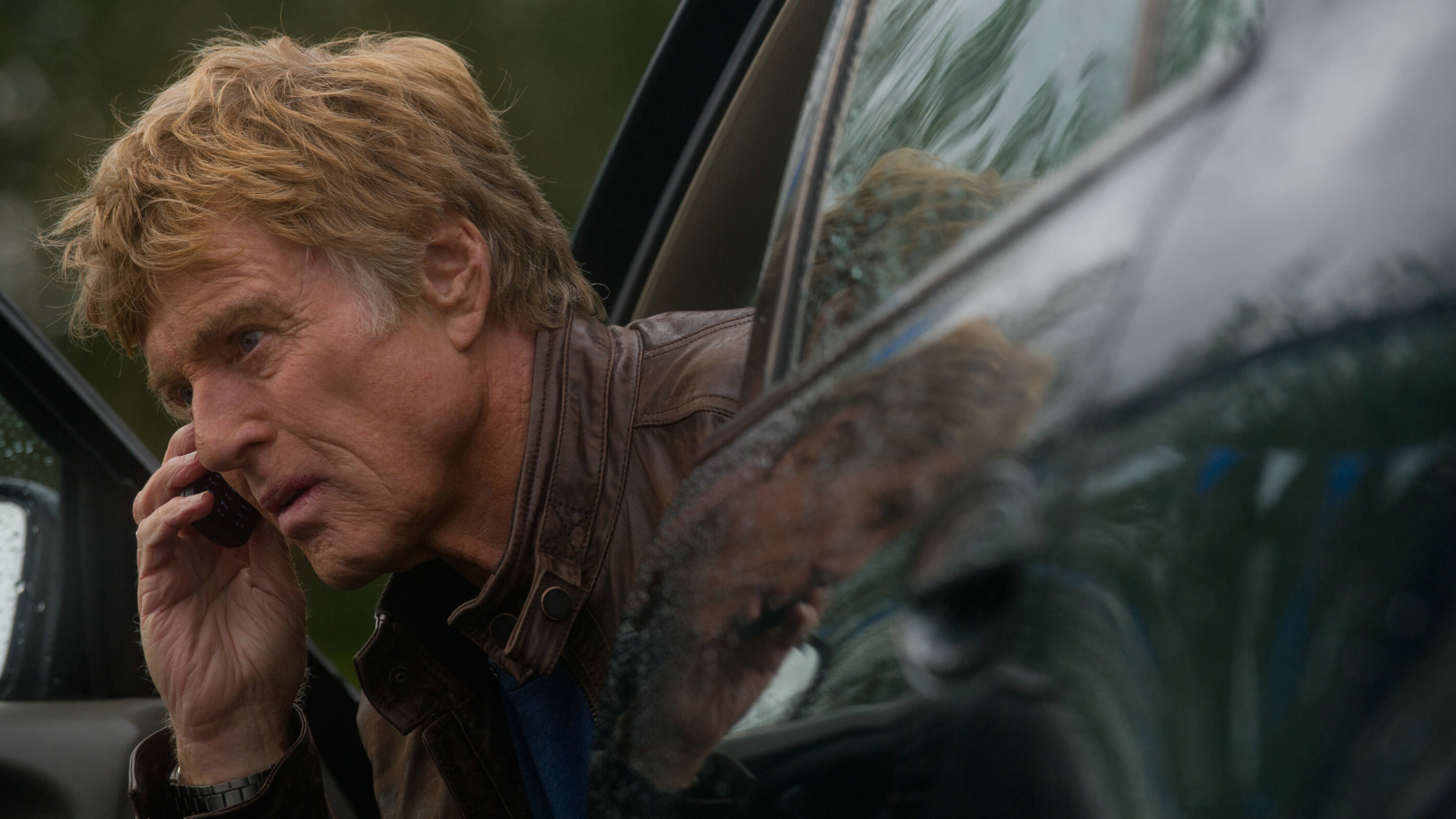 "Die Akte Grant": Jim Grant (Robert Redford) sitzt in der Tür eines Autos und telefoniert.