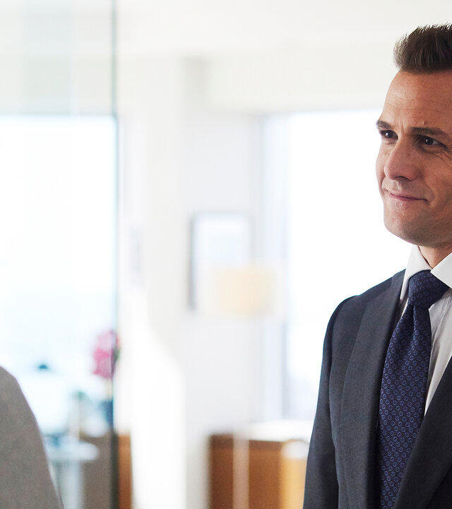 "Suits - Coral Gables": Harvey (Gabriel Macht) steht mit einem eleganten, dunklen Anzug bekleidet Samantha (Katherine Heigl) gegenüber, die im Profil zu erkennen ist. Er lächelt sie offen an.